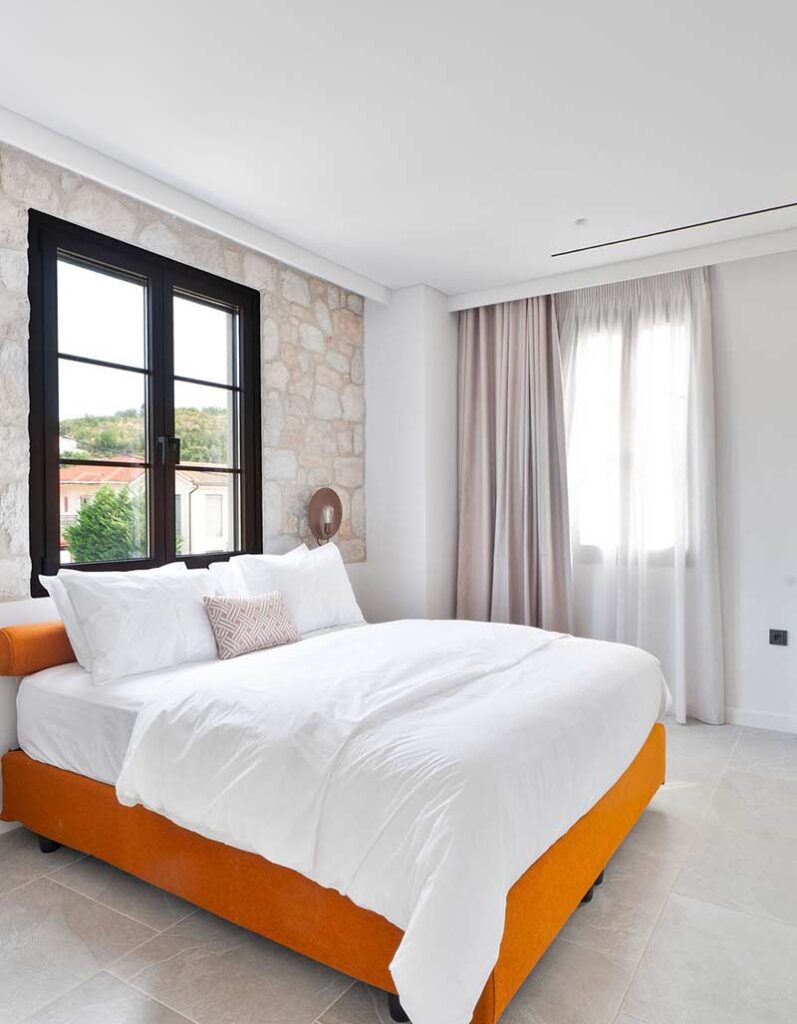 Modern bedroom interior design at Kepos Villas with ambient lighting and natural wood accents