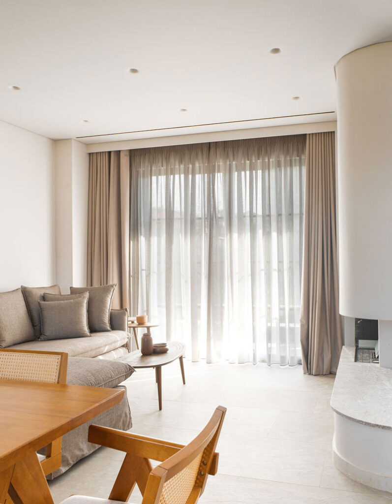 Minimalist stone fireplace in the main lounge area of Kepos Villas, creating a warm and inviting atmosphere.