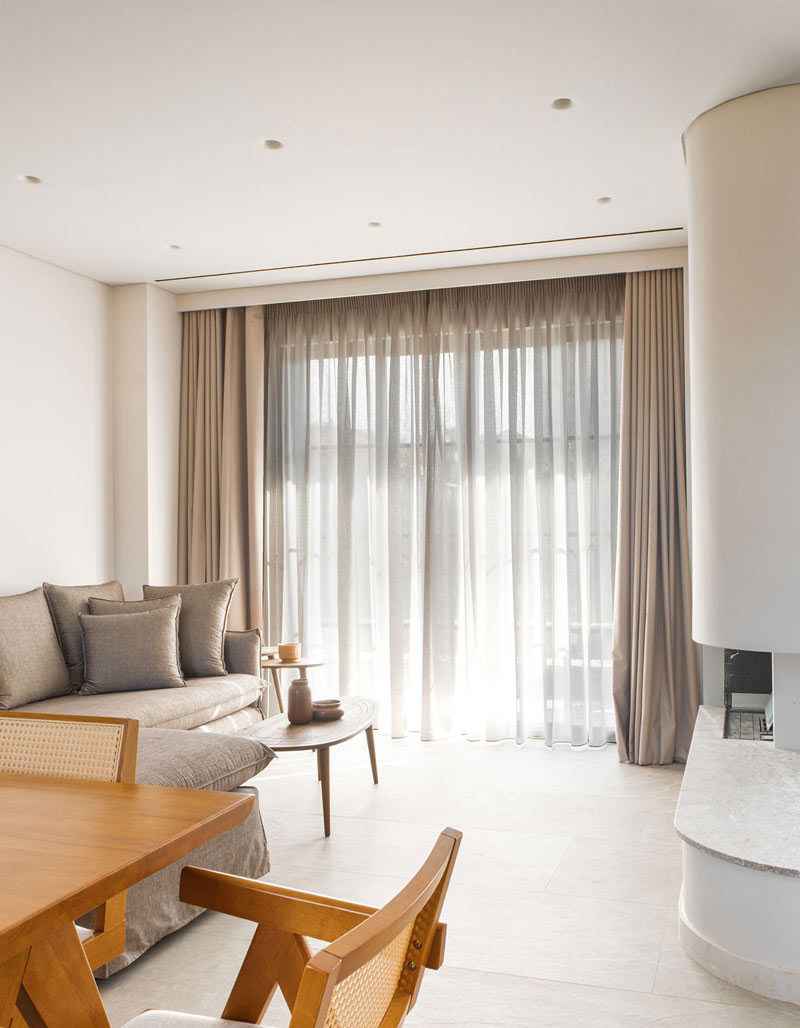 Minimalist stone fireplace in the main lounge area of Kepos Villas, creating a warm and inviting atmosphere.